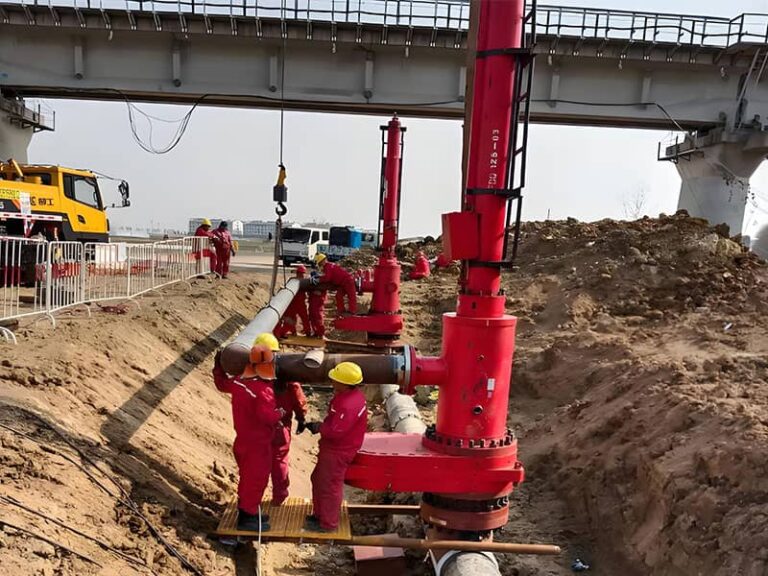 Workers and red equipment operating on pipeline under a bridge in Suqian gas pipeline relocation construction