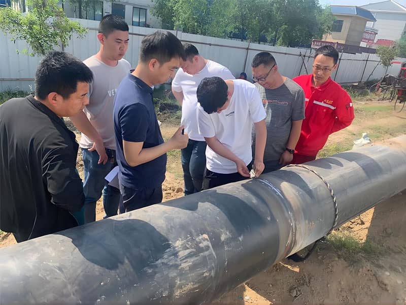 Workers inspecting natural gas pipeline at Yubei LNG emergency reserve center pipeline relocation site in Jiaozuo
