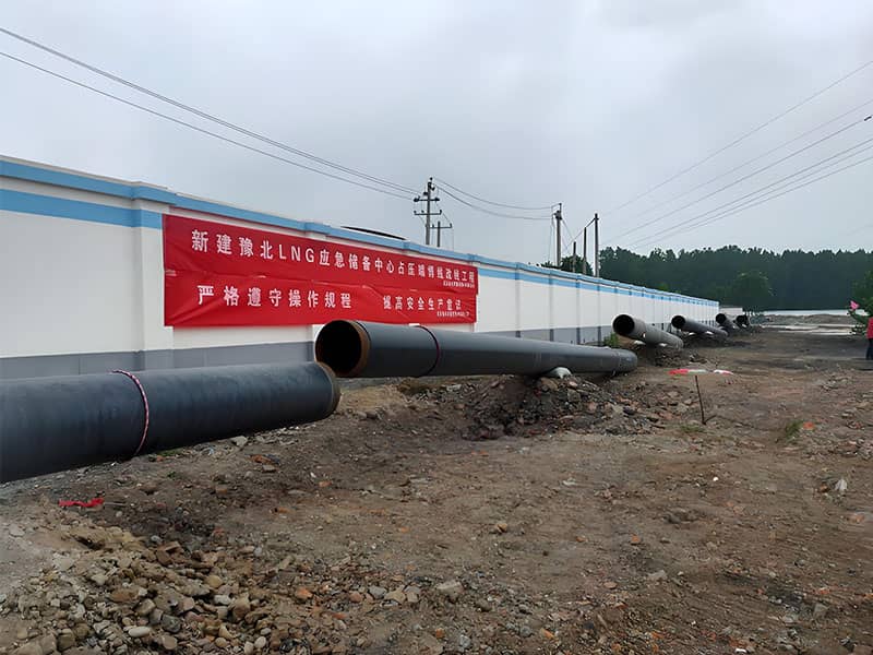 Laid natural gas pipelines and project banner at Yubei LNG emergency reserve center pipeline relocation construction site
