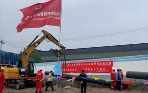 Workers, excavator and pipeline at Yubei LNG emergency reserve center pipeline relocation construction site in Jiaozuo, Henan