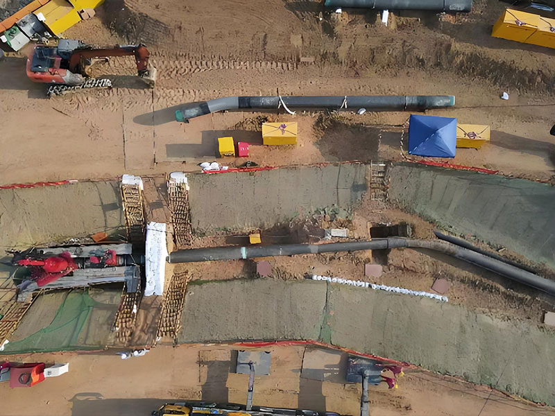 Aerial shot of Riyi crude oil pipeline (DN914) circumferential weld defect repair & plugging construction site in Rizhao: Excavated trench, pipeline, construction equipment and materials during the project
