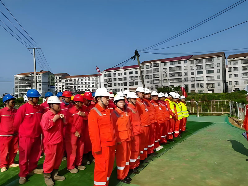 Group of workers in safety uniforms gathering before starting petroleum pipeline repair and replacement work (part of DN400 pipeline plugging project)