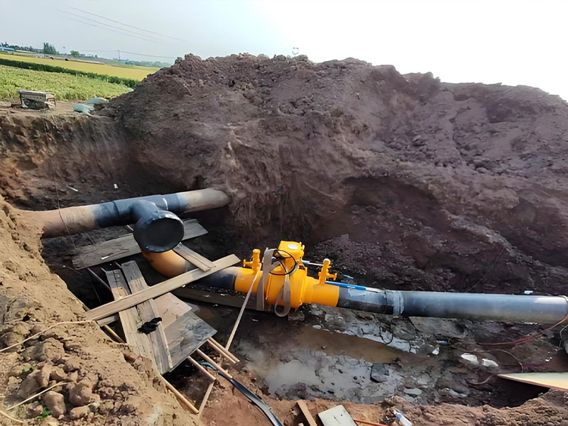 Yellow pipeline fittings (including valves) for natural gas pipeline hot tapping, installed on in-service pipeline in excavation pit