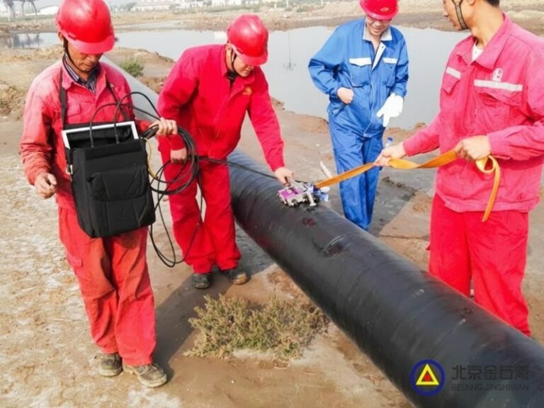 A team of technicians performing an external magnetic flux leakage (MFL) pipeline inspection using a robotic crawler to detect corrosion and metal loss.
