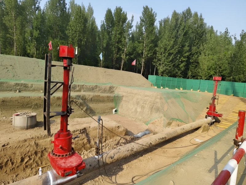 Máquinas industriales de roscado en caliente que realizan una modificación de tuberías en directo en una excavación al aire libre para mantener el servicio presurizado sin paradas.