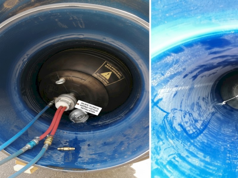 An inflatable industrial pipe plug being installed inside a large blue drainage pipe with dual-color pressure hoses and a label for on-site technical support.