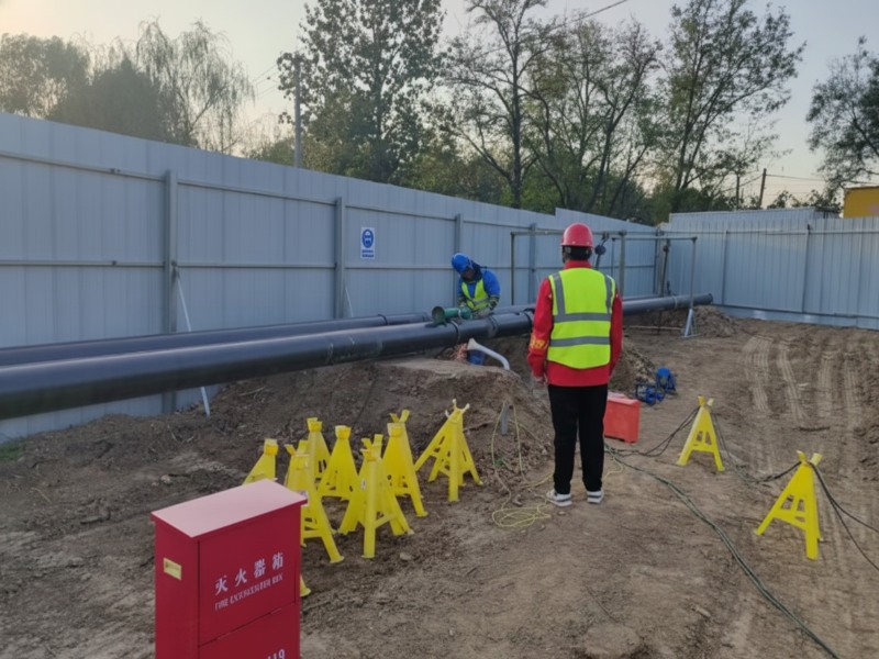 Construction workers in high-visibility vests and safety helmets relocate Sinopec refined oil and China Aviation fuel pipelines at the Wenchaio Jianhe River project site.