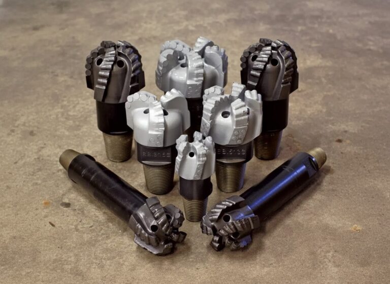 A collection of heavy-duty fixed cutter PDC rock drill bits in various sizes and finishes, designed for industrial drilling and mining applications.
