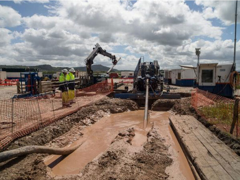 Horizontal directional drilling (HDD) trenchless construction project with drilling equipment and fluid management at a pipeline installation site