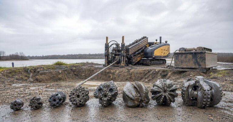 HDD reamer and cutters staged beside a trenchless drilling rig at an entry pit