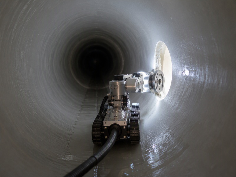 Robotic cutter reinstating a lateral connection inside a newly cured CIPP liner, guided by camera and clock position