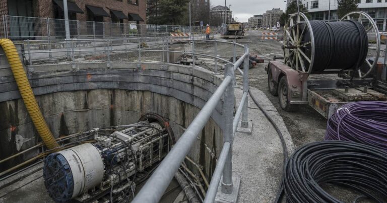 Guided microtunneling machine installing a small-diameter conduit casing for fiber optic and power cables below a city street