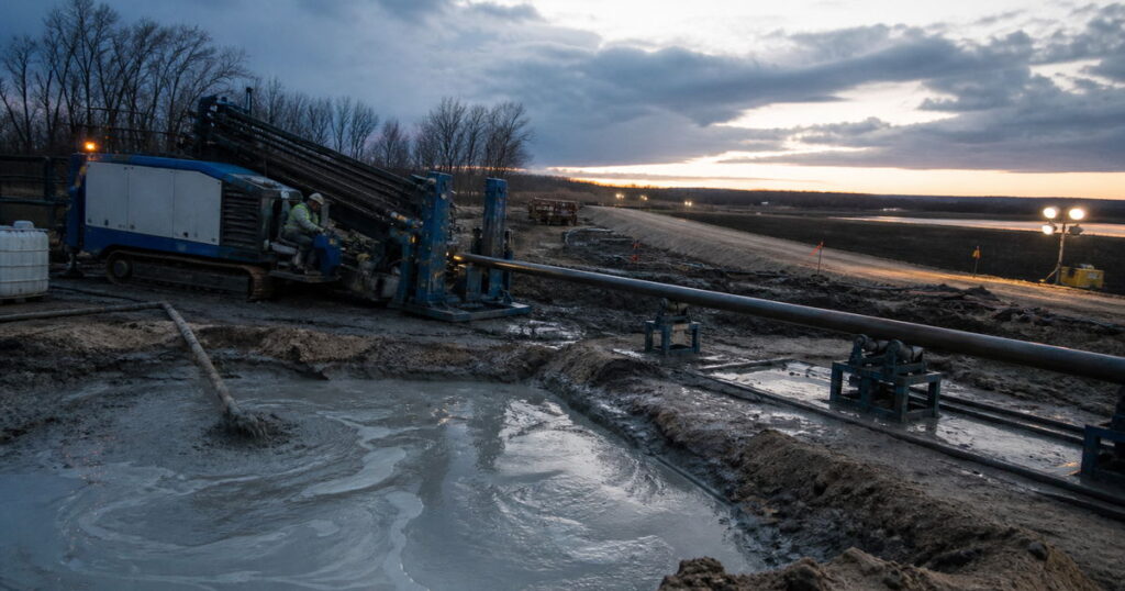 HDD rig on a pipeline crossing site with drilling fluid returns and product pipe staged for pullback